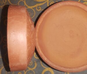 Ware has a dull appearance on the inside and is finished with Iron Oxide on the outside (as explained in the paragraph below...).